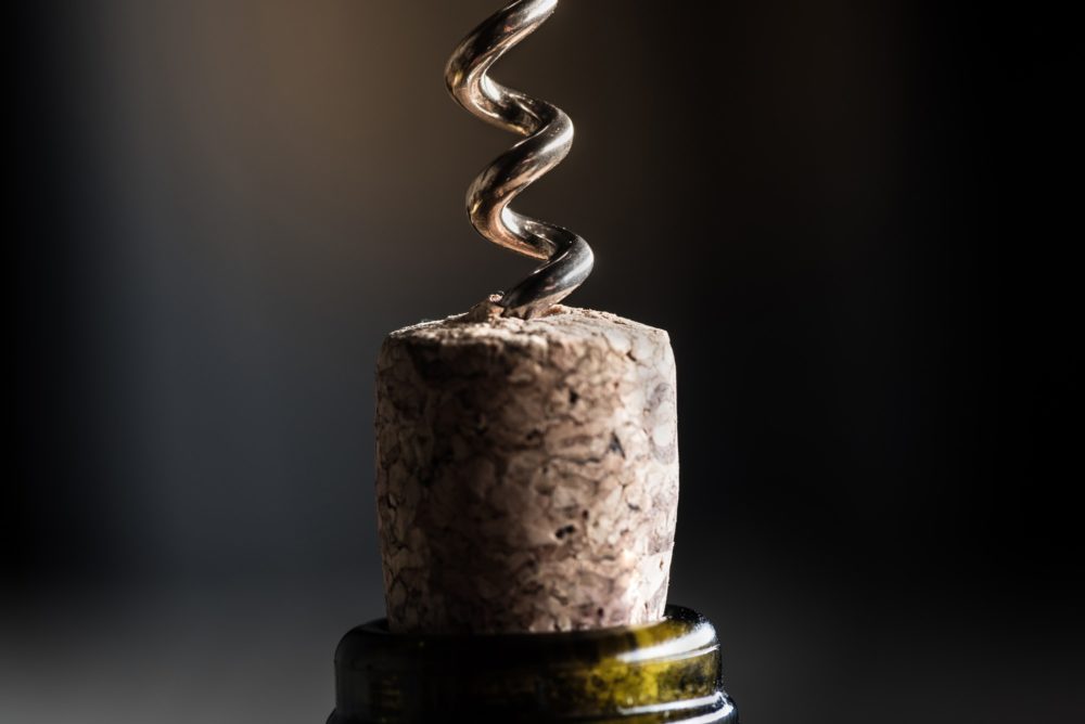 close up view of wine bottle with corkscrew with copy space